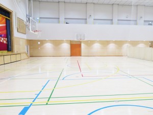 地下1階にある体育館。300人以上が着席できる移動式観覧席を備えています。