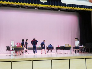 学校の式典が行われる体育館。ステージでは演劇部が練習しています。