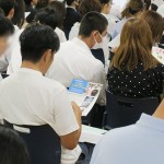 配布された資料を熱心に見る保護者と受験生