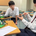 作品に指をさし、作品に注視しながら話者の説明をきく様子