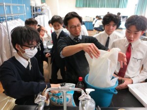 実験材料の砂利を用意する玉木教諭