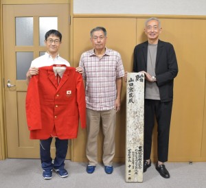 贈与していただいた踏切板とジャケット(中央はご遺族代表の山田眞人志様)